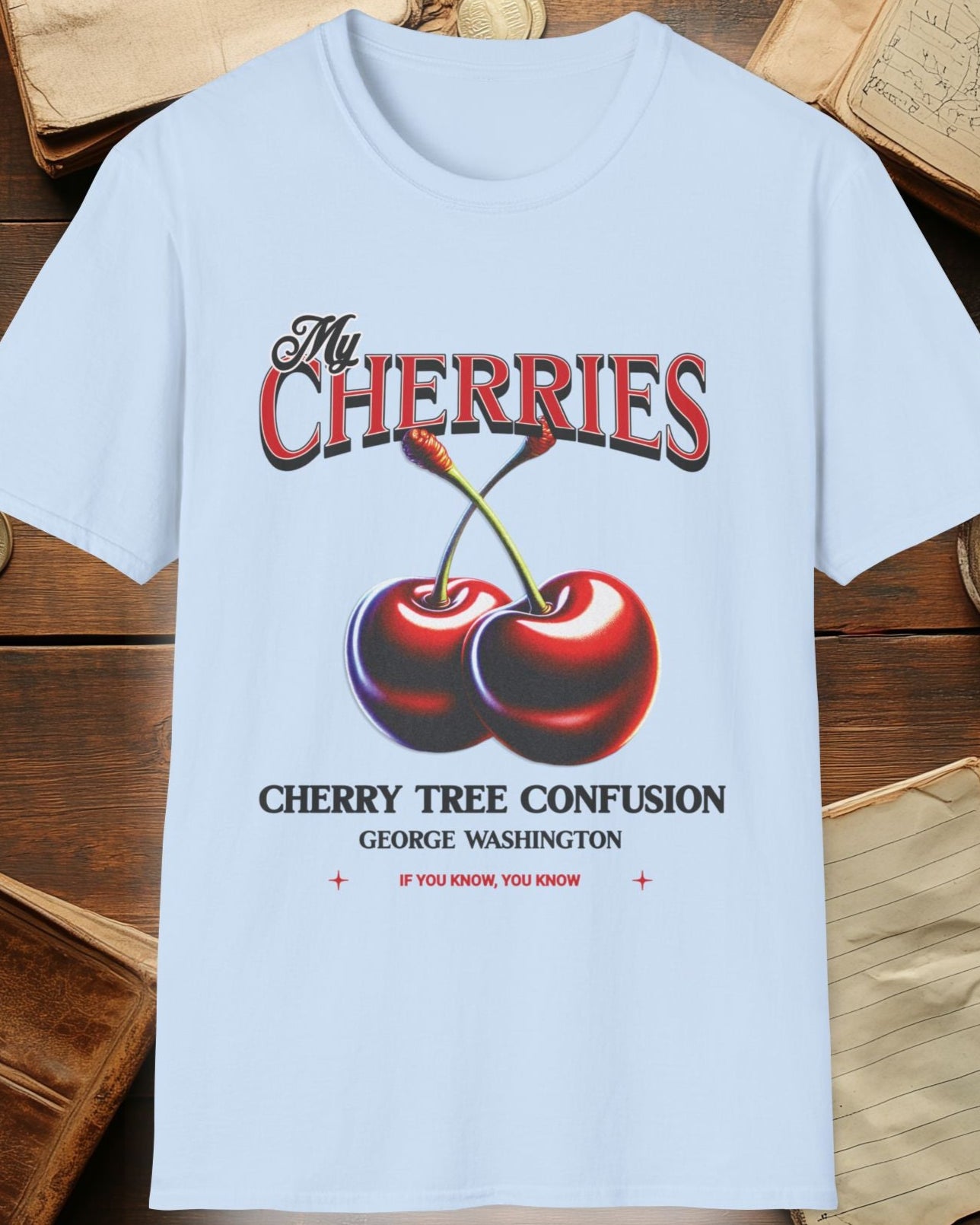 light bluetshirt with charries and the text "The cherries, cherry tree confusion"