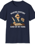 A navy blue short-sleeve t-shirt with a graphic print of a cartoon George Washington holding a newspaper that reads 'I, John Adams' while writing. The text above and below reads 'MAKING HISTORY IS - KIND OF MY THING' in white.