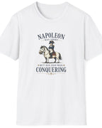 A white short-sleeve crewneck t-shirt featuring a vintage-style graphic of Napoleon on a horse with the text 'NAPOLEON WAS SHOT BUT HIS EGO WAS CONQUERING'.