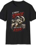 A black short-sleeve crewneck t-shirt featuring a graphic print of an astronaut sitting on a space station with the text 'I NEED SPACE SAID NO ONE EVER.' in red and white lettering.