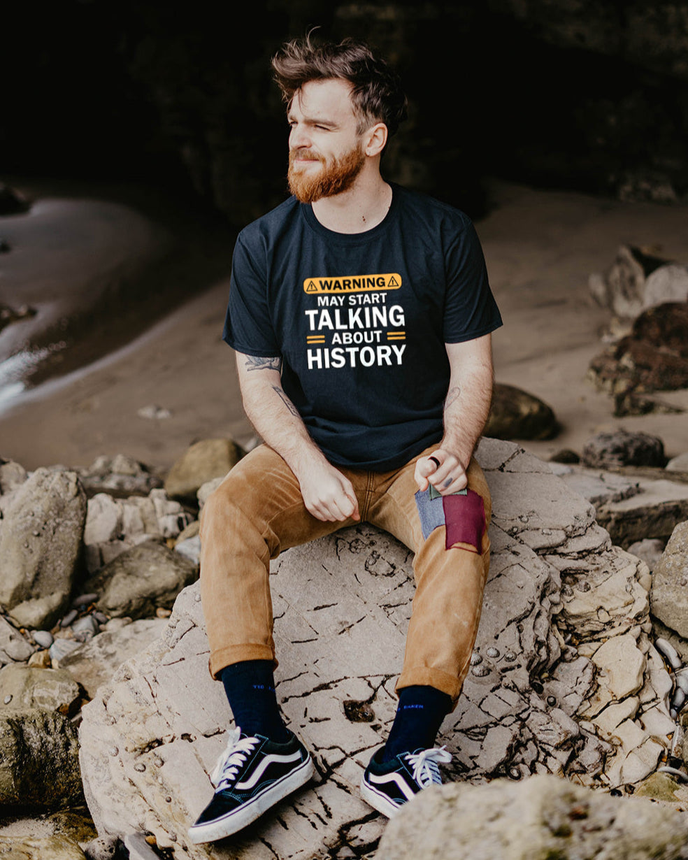 Black T-Shirt with the text "Warning! May start talking about history" in white. The t-shirt is on a male model. 