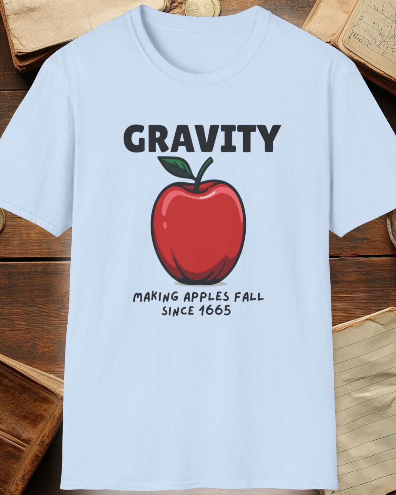light blue tshirt with a apple and the text "Gravity, Making apples fall since 1665"